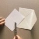 a person cutting out a piece of paper with a pen