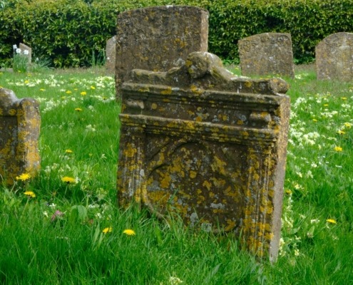 gray concrete tomb on green grass field during daytime